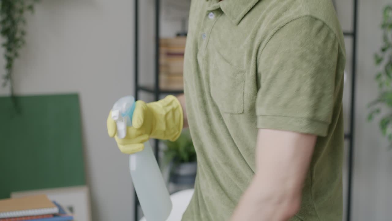 Man Cleaning a Desk with Spray Bottle