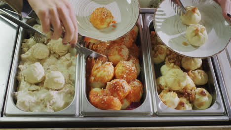 people put food on their plates. self service restaurant. view from above