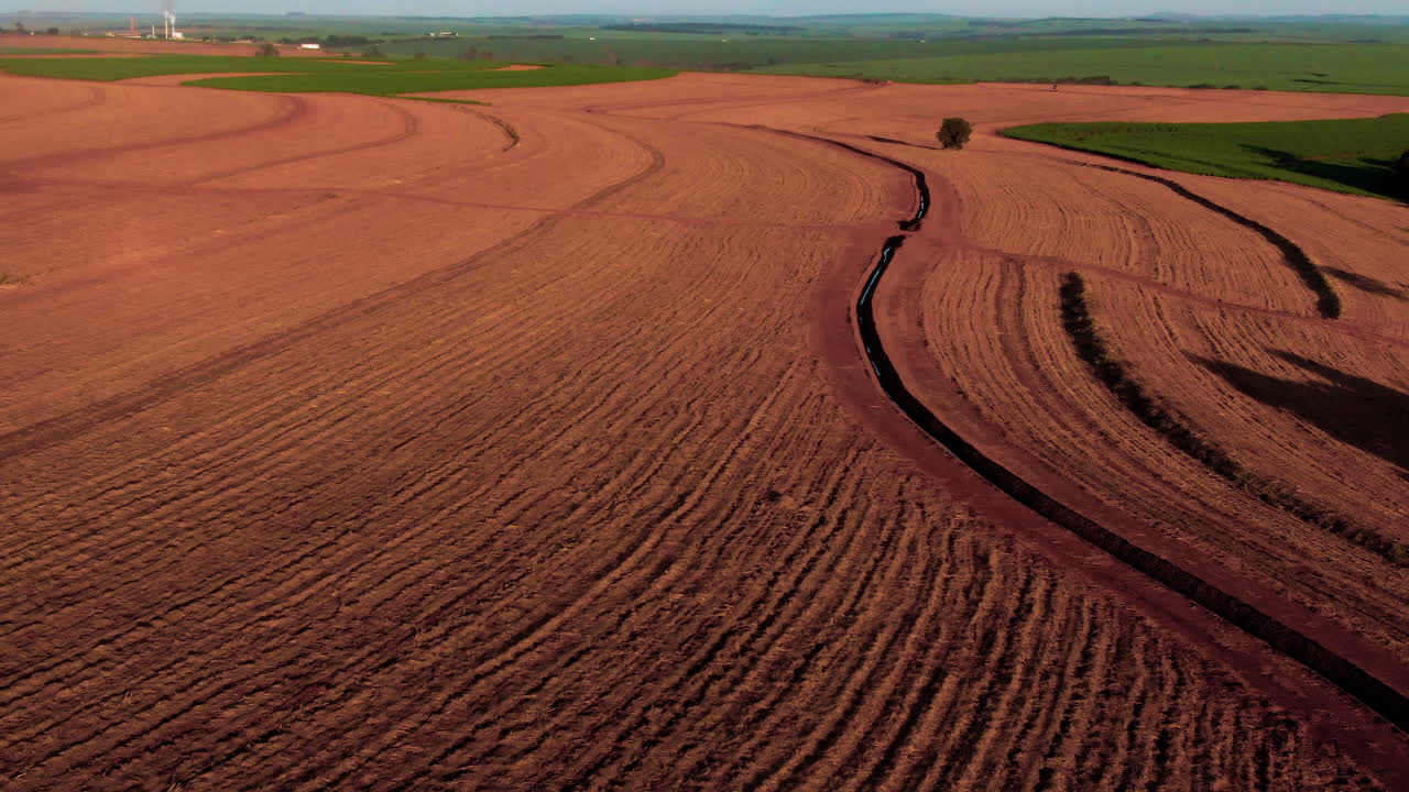 Prepared soil in a field, ready for planting crops, smooth texture, aerial view.