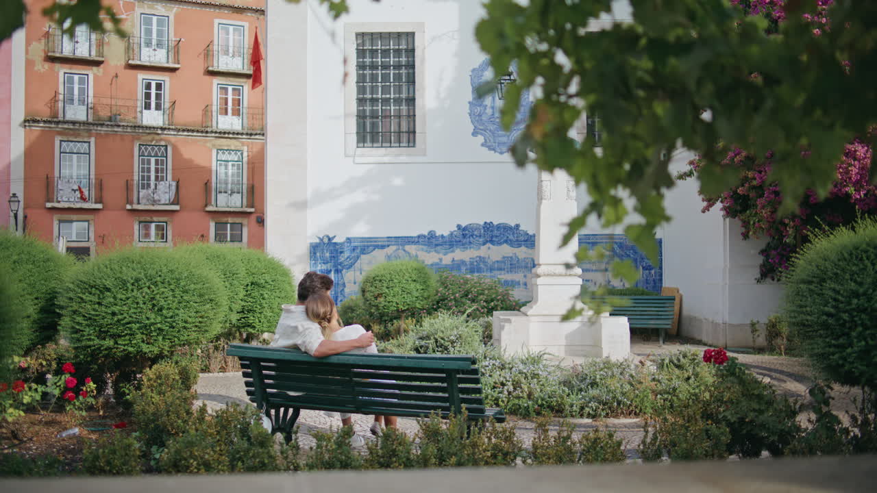 만적 인 커플이 부드럽게 포옹하고 앉아있는 공원 벤치 뒷면. 사랑 개념