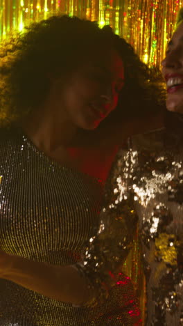 Vertical-Video-Of-Two-Women-In-Nightclub-Or-Bar-Dancing-Drinking-Alcohol-With-Sparkling-Lights-In-Background-3