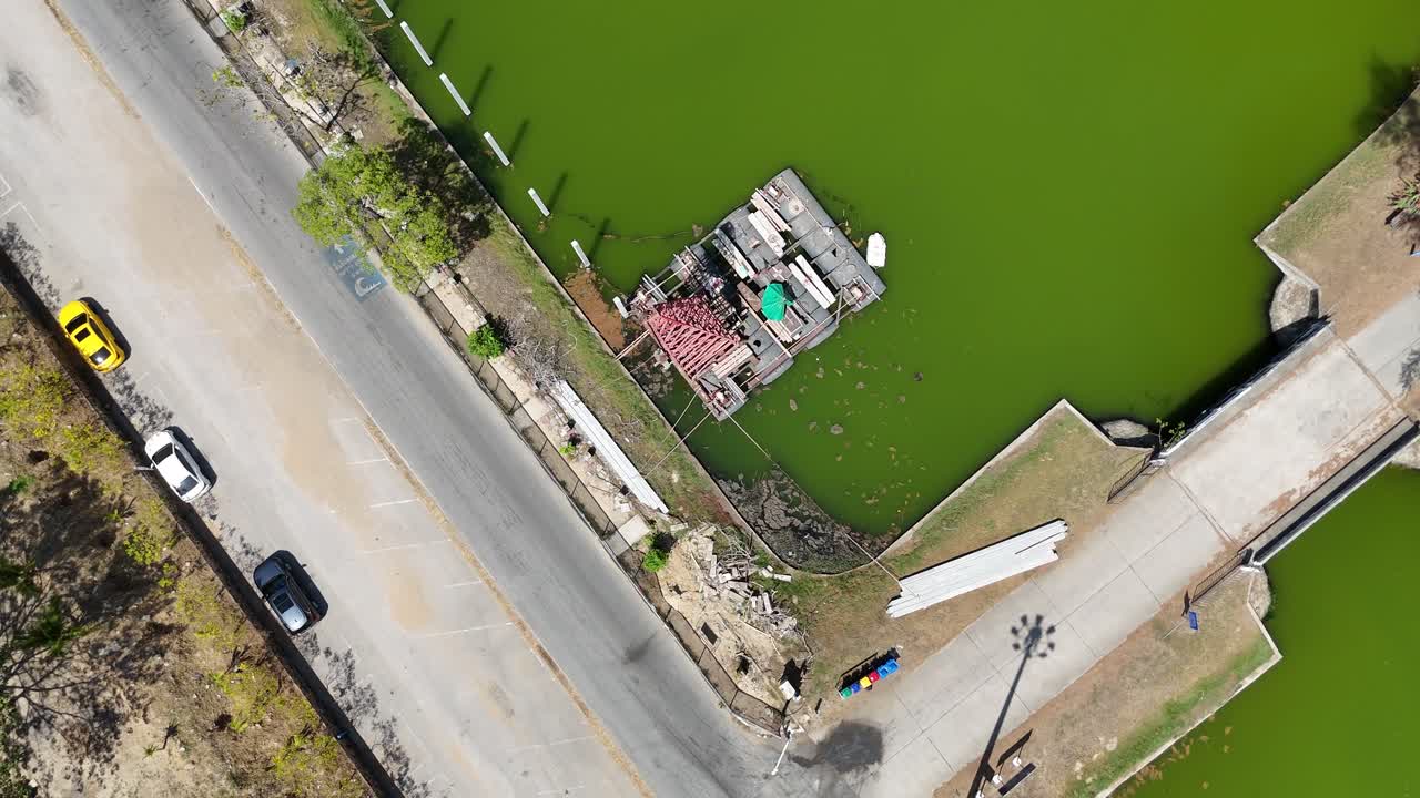 las imágenes de drones capturan una vibrante vía fluvial verde en phuket, tailandia, con carreteras cercanas y un pequeño muelle visible