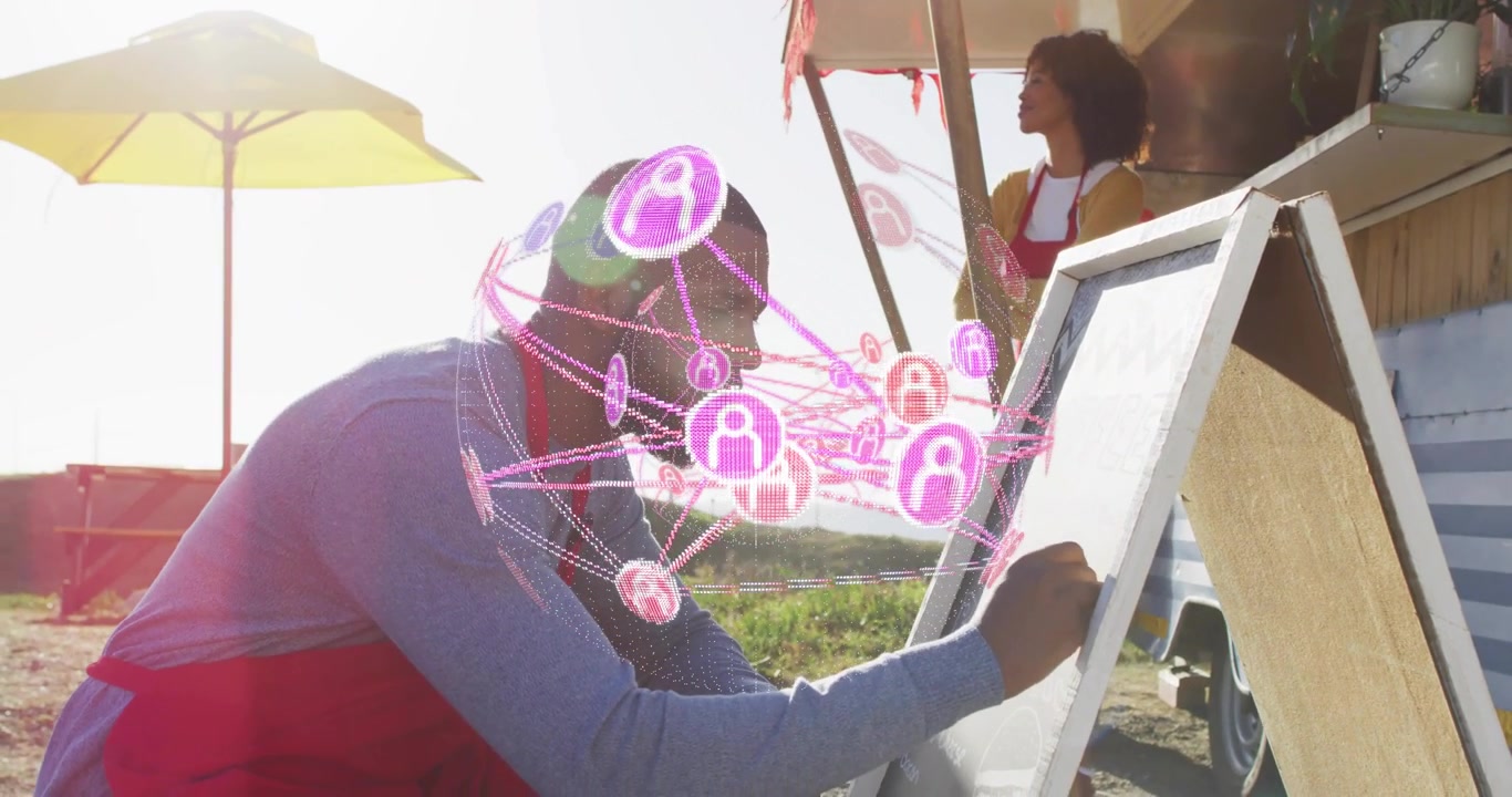 Vendor kneeling writing board for food truck marketing, initiating animated pink network overlay