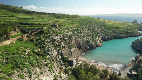 aerial: hills of magrr ix-xini bay with mediterranean sea water washing shores of gozo island