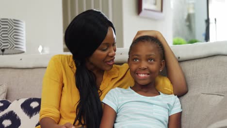 mother and daughter watching television in living room 4k