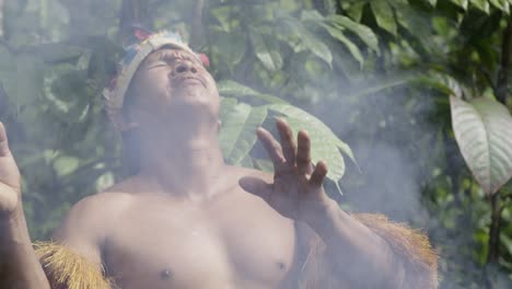 An-indigenous-man-performs-a-ritual-using-smoke-in-the-dense-forest-of-Leticia,-Amazon,-Colombia