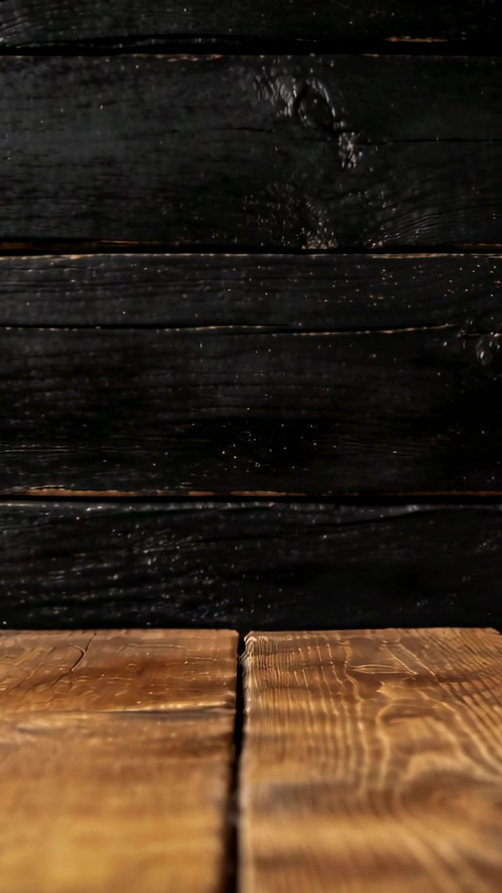 Video verticale: Telecamera che si sposta verso l'alto sopra un set da tavolo in legno, rivelando una giuntura scura tra le assi.