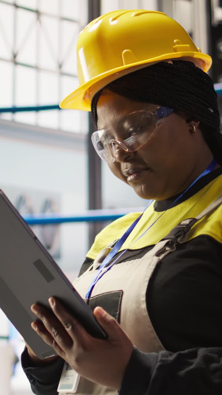 Vertical video Solar panels plant expert uses tablet to oversee systems, close up