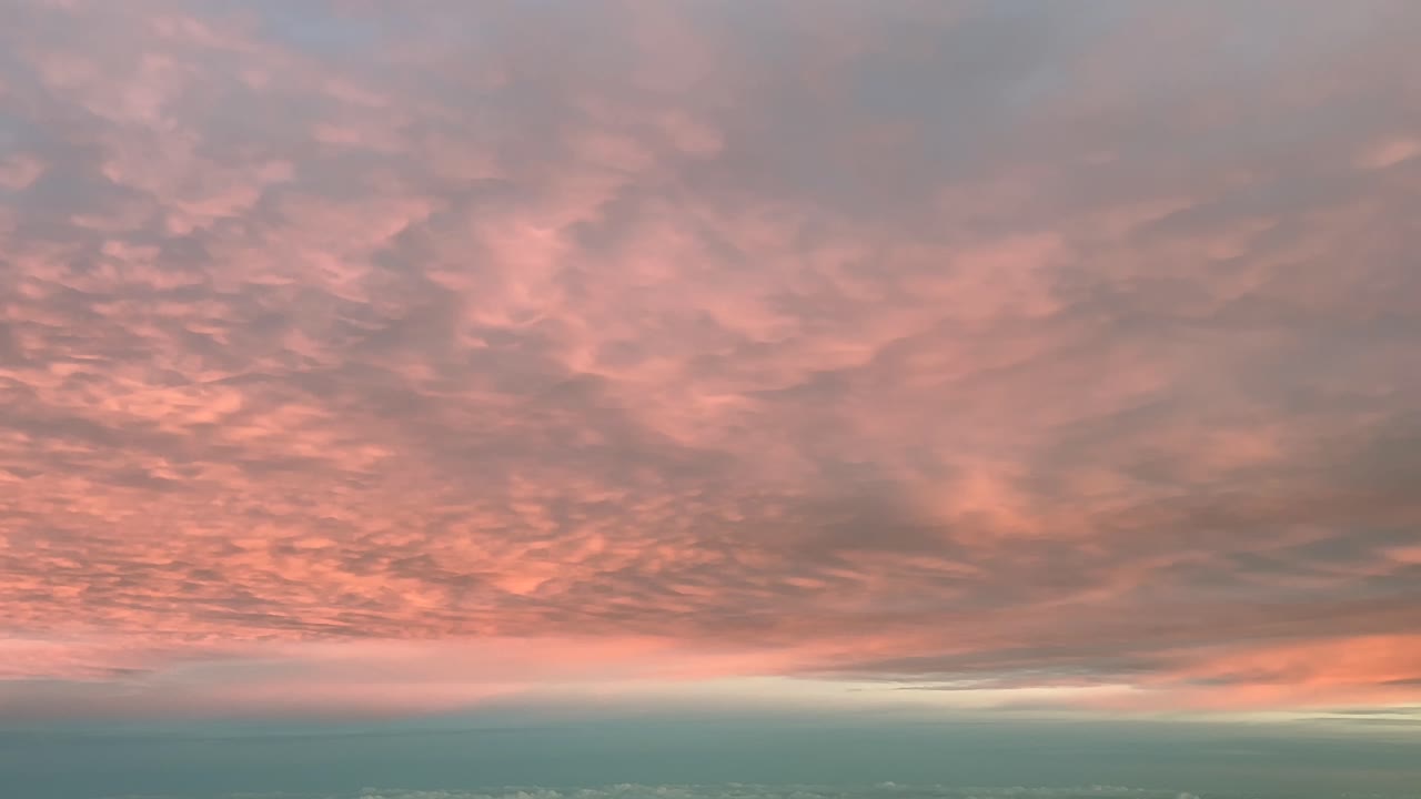 pov volando bajo una intensa nube de color naranja disparada desde una cabina de avión al amanecer