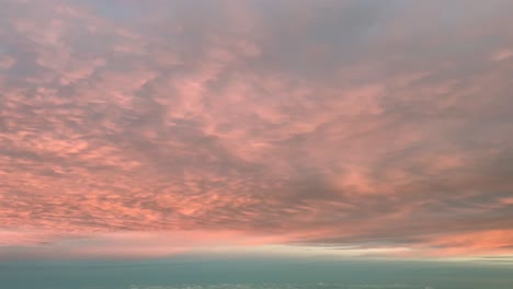 pov volando bajo una intensa nube de color naranja disparada desde una cabina de avión al amanecer