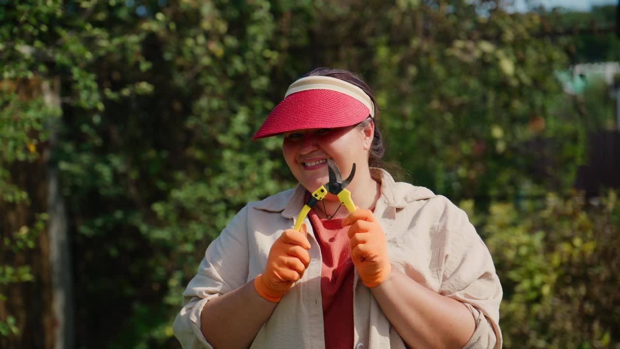 Aficionado a la jardinería podando plantas con herramientas en un exuberante jardín verde, con guantes protectores y visera, disfrutando del día soleado al aire libre y cuidando la naturaleza