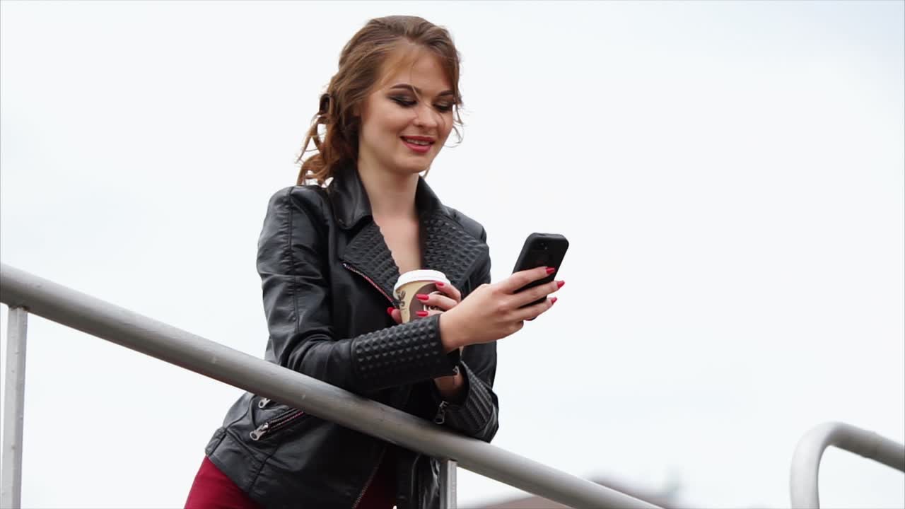 Donna che per mezzo del telefono all'aperto