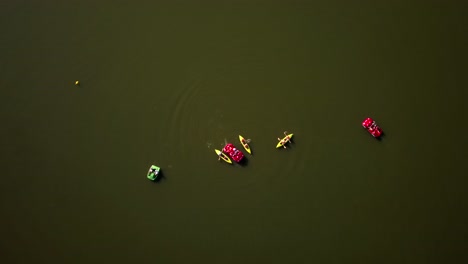 Aerial-top-down-shot-of-a-group-of-people-kayaking-and-boating-on-Goldap-Lake,-Poland