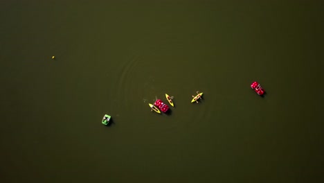 fotografía aérea de arriba hacia abajo de un grupo de personas haciendo kayak y botes en el lago goldap, polonia