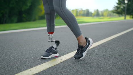 mujer discapacitada calentando las piernas antes de correr. niña haciendo ejercicio en la superficie de carrera