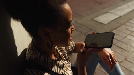 Mixed-race-woman-talking-on-smartphone-under-bridge