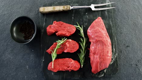 raw meat and rosemary on the board