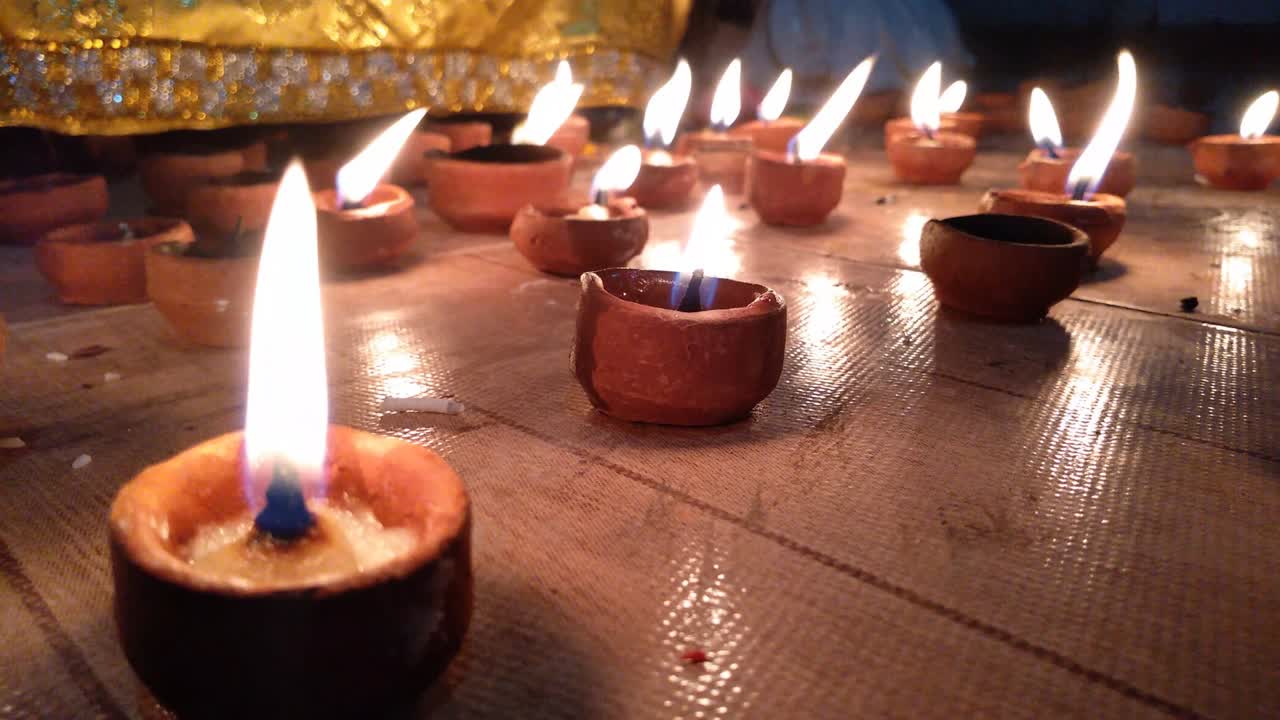 feliz diwali - pequeñas lámparas de arcilla dia encendidas durante la celebración de diwali. un montón de arcilla diya ardiendo delante de dios para la adoración.