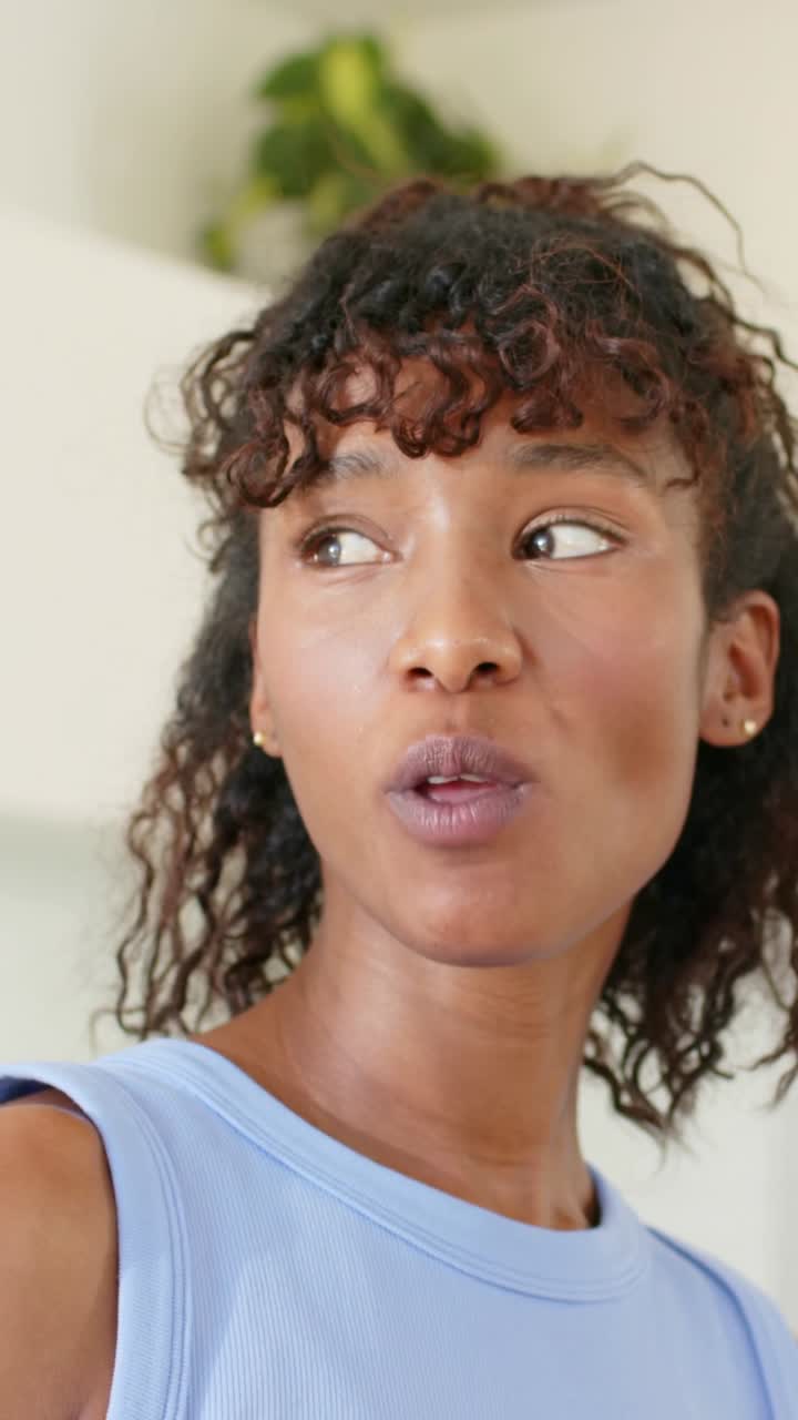 Vertical video: Lifting red bite, woman in blue top tasting and judging taste at home with plant