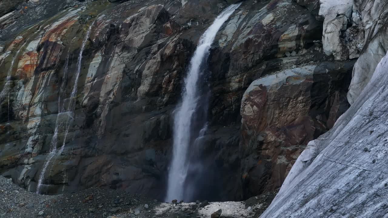 arroyo de cascada que fluye desde el glaciar a lo largo de la pared rocosa