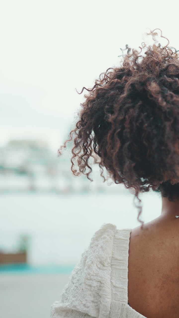 Woman with curly hair looking at the city