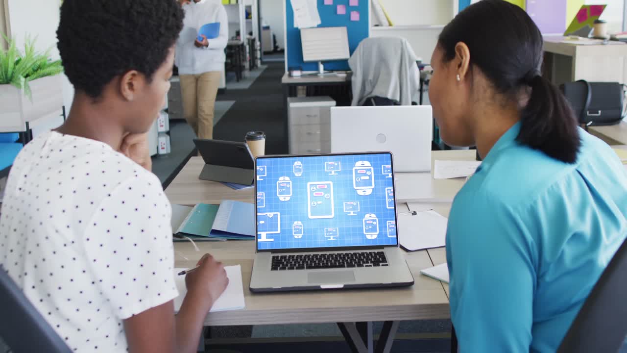Diverse business people using laptop with digital chat on screen in office