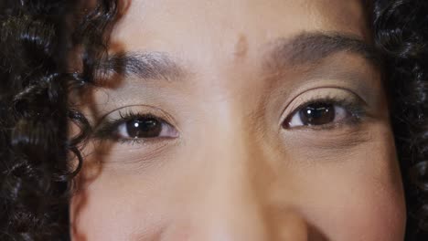 Portrait-close-up-of-happy-biracial-businesswoman-smiling-to-camera,-in-slow-motion