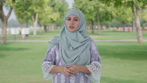 muslim woman talking at the camera in park