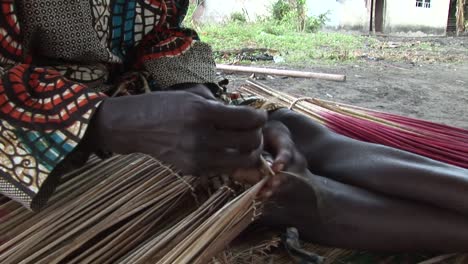 african woman crafting a mat. nigeria