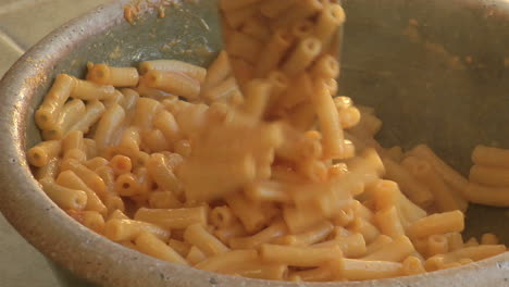 macaroni is stirred in a bowl