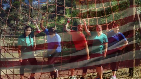 group of women standing under a cargo net obstacle course