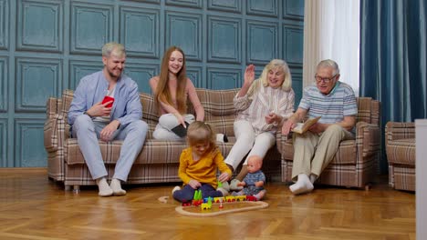 multigenerational family leisure at home, motivating shouting to child kid girl playing railway toy