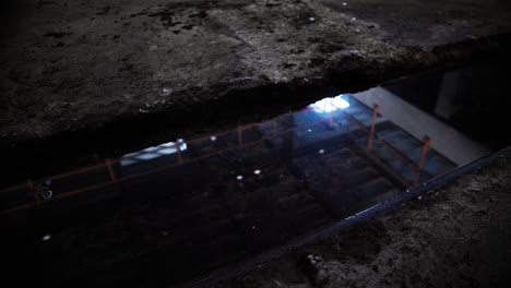 Empty-abandoned-building-skeleton,-concrete-pillars-and-pools-of-water