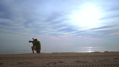 Fotógrafo-Tomando-Fotos-De-La-Puesta-De-Sol-En-El-Mar.-Fotógrafo-Con-Cámara-Al-Atardecer-En-El-Mar.