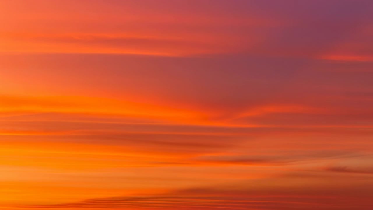 Horizonless warm orange sky filled with soft horizontal streaks of clouds and a smooth amber-to-apricot gradient. Diffuse sunlight creates an even glowing