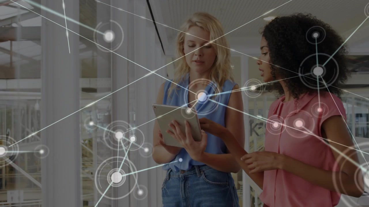 Two women tapping tablet initiating network expanding over pair while visualizing business data