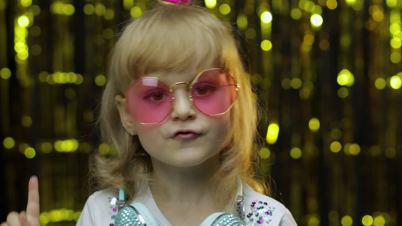 niño baila, escucha música en los auriculares. niña pequeña bailando, teniendo hun, relajándose, disfrutando