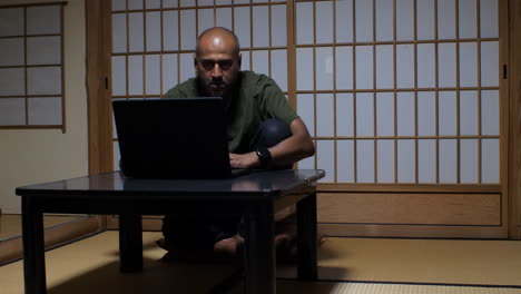 En-Un-Ryokan-Japonés-Tradicional,-Un-Hombre-Calvo-Integra-A-La-Perfección-La-Tecnología-Moderna-En-Un-Ambiente-Sereno.