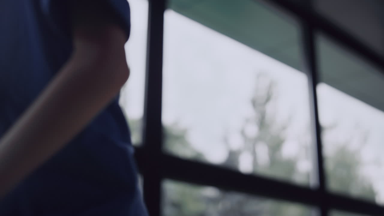 불행한 학교 소년은 창문을 보고 홀을 가 ⁇ 게 앉는다. 소년은 홀을 떠나서 일어난다.