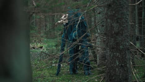 mystical monster with skull of animal standing in dense forest