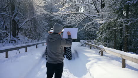 person drawing in a snowy winter forest
