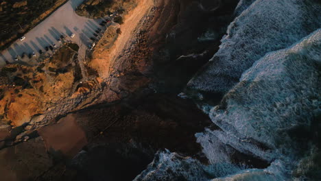 tiro de drone de cima para baixo de ondas e litoral ao pôr do sol