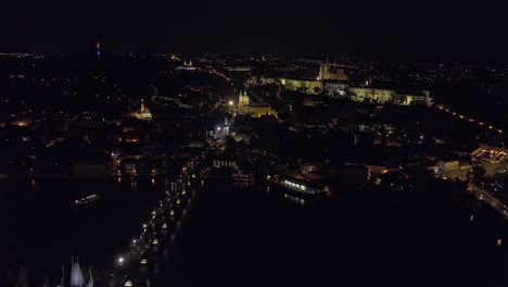 Prague-Czechia-Aerial-v89-drone-flyover-Vltava-river-along-Charles-bridge-towards-Mala-Strana-capturing-castle-on-the-hilltop-of-Hradcany-and-night-cityscape---Shot-with-Mavic-3-Cine---November-2022