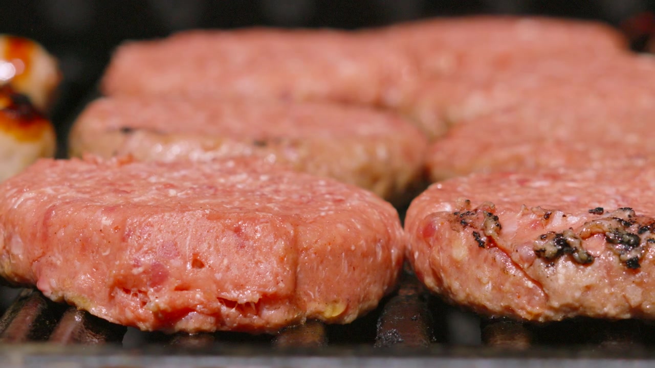 Close-up of Fresh Raw Beef Burgers with Soft Heat Distortion from Hot Grill. Tasty Summer Food. 4K.
