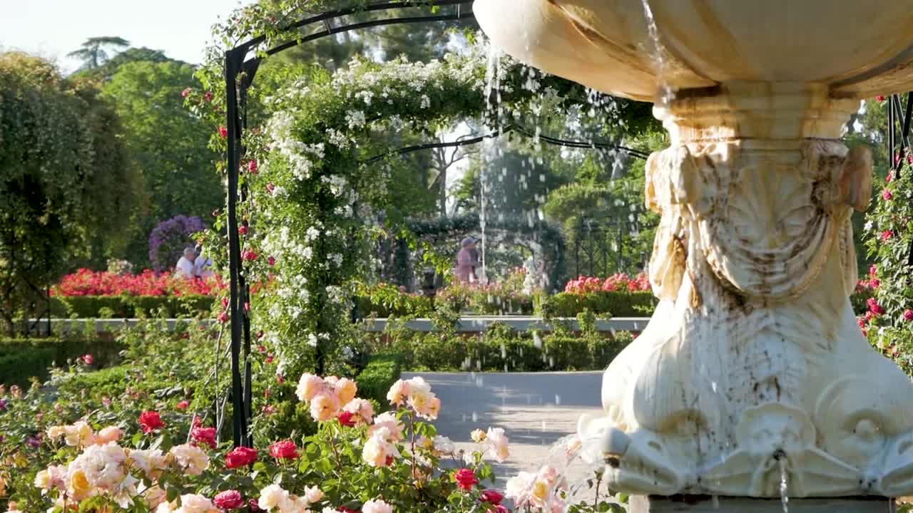 Fountain spilling water in a flower garden. Serene and picturesque garden scene.