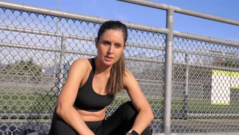 mujer atlética fatigada sentada descansando después de correr