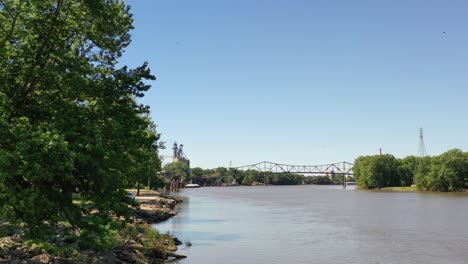 beautiful park along side a river with a bridge in the background from a aerial view