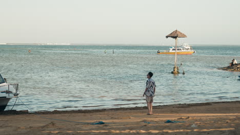 asian man walk toward bali beach on vacation holiday with sunglasses wide