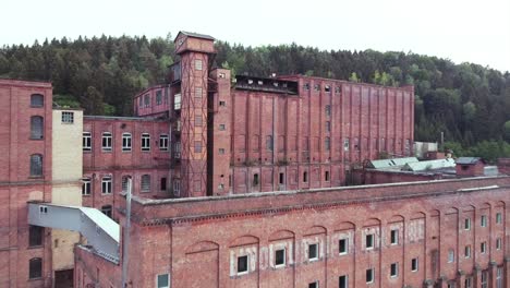 drone approaching a giant old brick factory in the evening sun a lost socialist place in the middle of germany