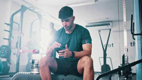 man using phone at the gym